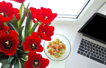 Flowers with a laptop close-up in the workplace.