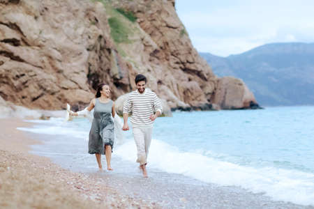 Frame shoot of couple walking on beach together in love holding each other by handの写真素材