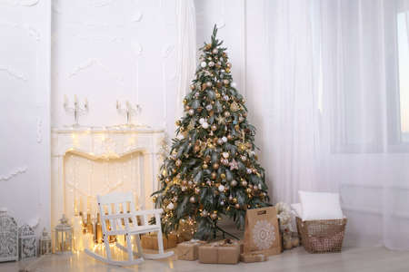 Christmas decorations gift boxes in wrapping paper near Christmas treeの写真素材