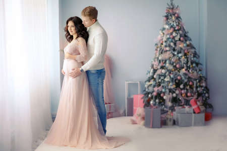 Young happy married couple on new years day . Exchange Christmas gifts and hugの写真素材