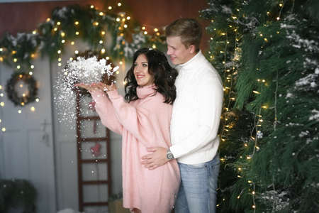 Young happy married couple on new years day . Exchange Christmas gifts and hugの写真素材