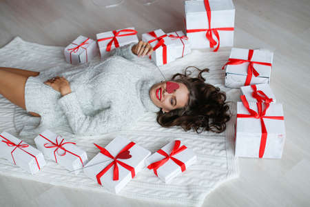 Attractive beautiful and sexy woman with perfect smile and teeth. With makeup at birthday or valentines day holding gift and balloonsの写真素材