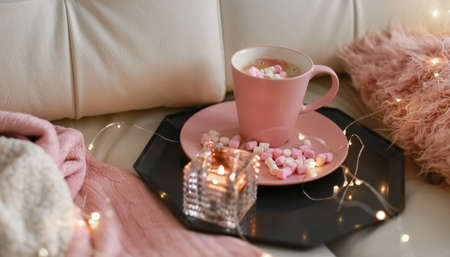 Romantic composition of a Cup of hot coffee pink on a light beige sofaの写真素材
