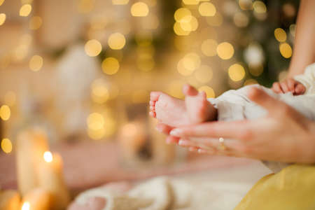 A young mother on new years eve holds a baby in her armsの写真素材