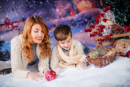 The child together with his mother at home against the background of New Years decorationsの写真素材
