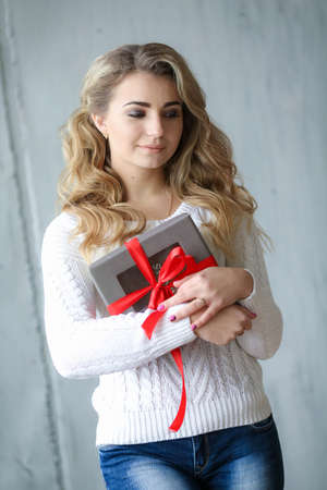 Woman holds a gift in a box on a birthday or new yearの写真素材