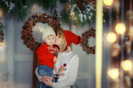Family photo for Christmas mom with daughter small child near red holiday boxesの写真素材