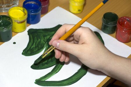 draw a tree a fir with brush and green paint on a white sheet of paper, gouache, creativity, drawing, handの写真素材