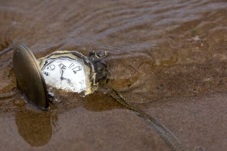 pocket watches round on the sand under the water, timeの写真素材