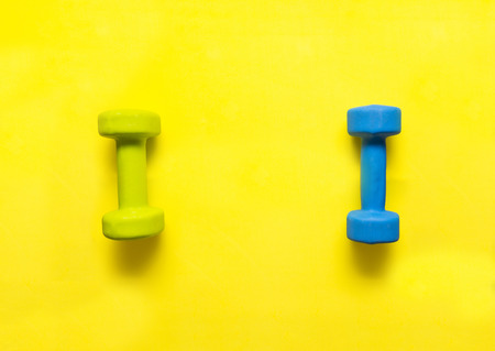 blue, green,  two, dumbbells, yellow background, flat lay,  still lifeの写真素材