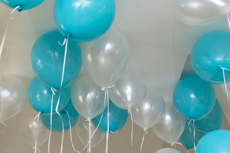 white and blue air helium balls with ropes hang under the ceilingの写真素材