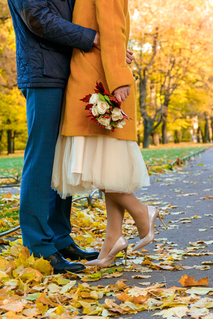 couple is hugging, the girl is holding a wedding bouquet of white roses in her hand,  autumn, a bouquet of the bride,の写真素材