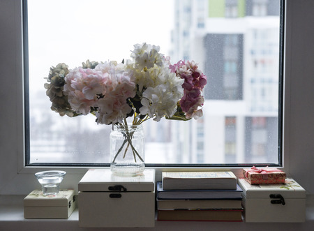 hydrangea flowers, boxes, books near the window