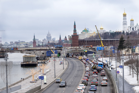 cars on the embankment of the Moscow river, the Moscow Kremlin, city view, Moscow in winter in cloudy weatherの写真素材