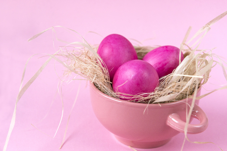 3 Easter eggs in pink plate on pink backgroundの写真素材