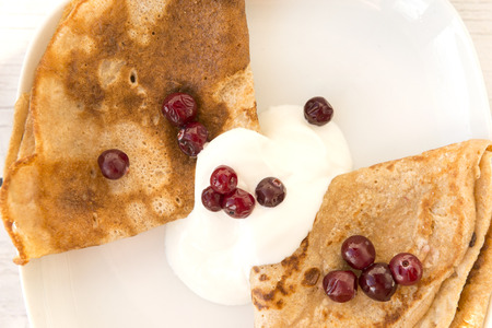 pancakes in sour cream and cranberries on a plate, berries,
