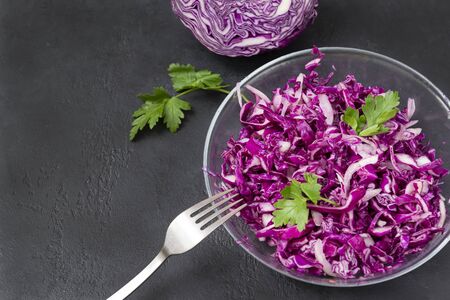 1 plate of vegetable vitamin salad on a black background, salad of fresh red cabbage with herbs, half a fresh head of cabbage, の写真素材