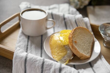 sandwich with scrambled eggs and cheese on wheat bread, 1 Cup of black coffee on a tray,の写真素材