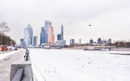 view of Moscow city, embankment Moscow river under the ice in winter, snow, flock of birdsの写真素材