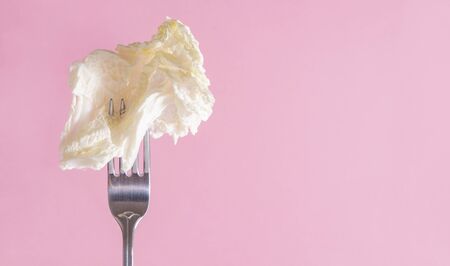 1 white lettuce leaf on a fork on a green background, Peking cabbage,の写真素材