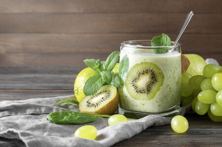 natural yoghurt with fresh kiwi, green Apple, spinach, grapes and mint on a grey napkinの写真素材
