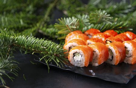 Japanese rolls with salmon Philadelphia , green spruce branch on a black background, sushiの写真素材