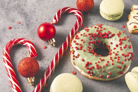 red lollipops, donuts, cookies, green macaroons, red Christmas balls on a gray background, Christmas sweetsの写真素材