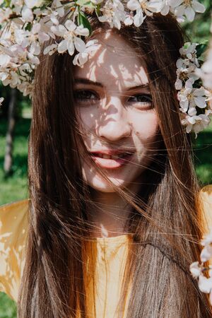 1 white young woman with brown hair among Apple blossoms, smileの写真素材