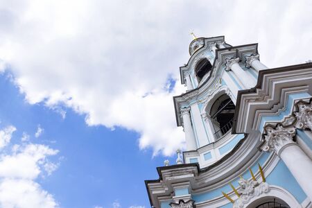 tower of the Orthodox Church in the classic blue style, an old beautiful building against a blue sky with cloudsの写真素材