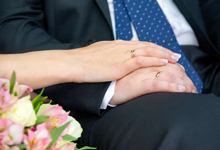 hands of the bride and groom with gold wedding rings, newlyweds, weddingの写真素材