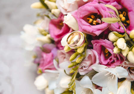 Bridal bouquet with pink and white flowers, 2 gold wedding rings, weddingの写真素材