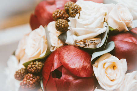 bride bouquet of red peonies, white roses, 2 gold wedding rings, wedding decor, flowersの写真素材