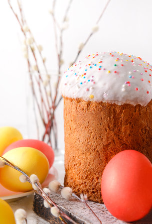 easter cake with willow twigs pink and yellow eggs on a light backgroundの写真素材