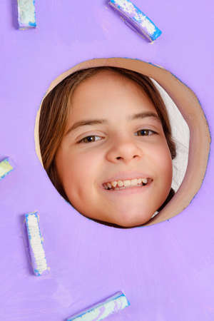 1 white teenage girl looks through a round hole on a lilac background