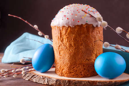 easter cake with willow twigs and blue painted eggs on a dark background