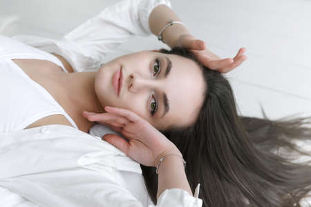 white european young brunette woman in white shirt close upの写真素材