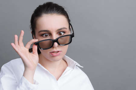 1 white young woman with glasses with a tired funny expression on a gray background close upの写真素材