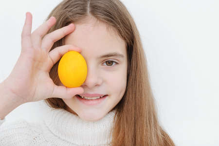1 cute white girl 10 years old with a yellow easter eggの写真素材