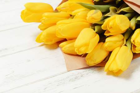 many yellow tulips on a white wooden background, bouquet of flowersの写真素材