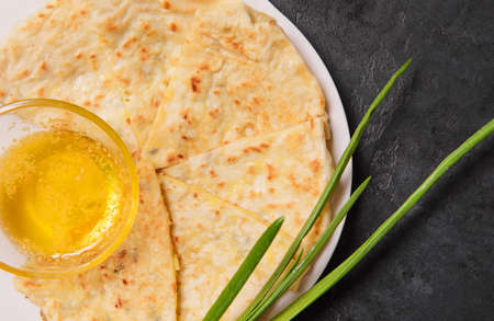 Ossetian pie with cheese and herbs, green onions, melted butter, Caucasian national cuisineの写真素材