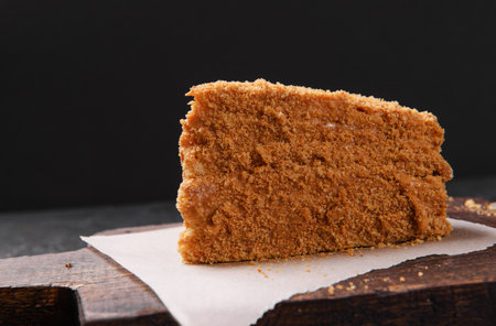piece of honey cake on the board side view, dessert