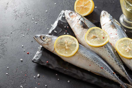 3 raw fish, mackerel, lemon on a dark background, seafoodの写真素材