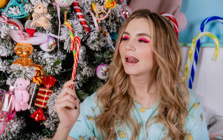 White beautiful girl with christmas tree facial sexy close up pijama candy make up holidayの写真素材