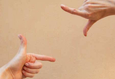 two hands showing a frame with their fingers on a simple brown backgroundの写真素材