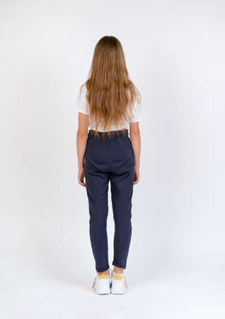 Young girl in blue trousers and white t-shirt model snap back look on white backgroundの写真素材