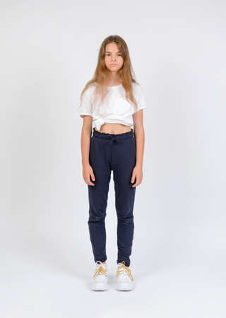 Young girl model snap in blue trousers and white t-shirt front look full length on white backgroundの写真素材