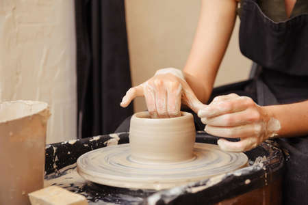 human hands making pottery circle, traditional potter, clay, workshop,