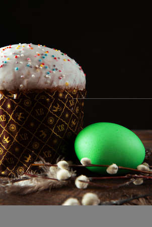 Easter cake with green egg and willow branches feather side look dark spring festive holidays...