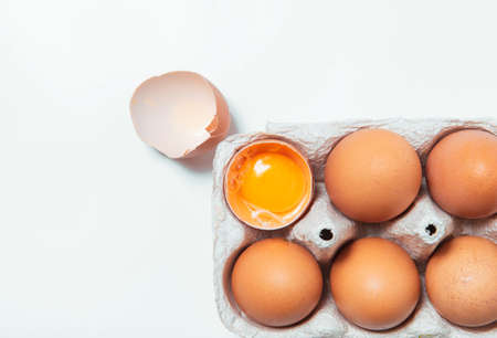 Egg shell yolk broken together on white background paralleled spring fresh products