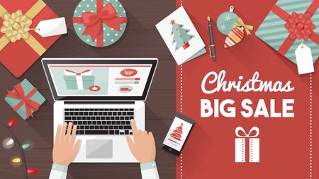 Man purchasing Christmas gifts online using a laptop on his desk, shopping bags and decorations all around, holiday and celebrations bannerのイラスト素材